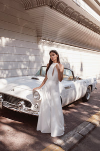 bride standing next to white vintage car in wide leg bridal jumpsuit