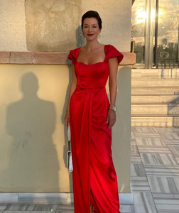 women standing in red satin evening gown